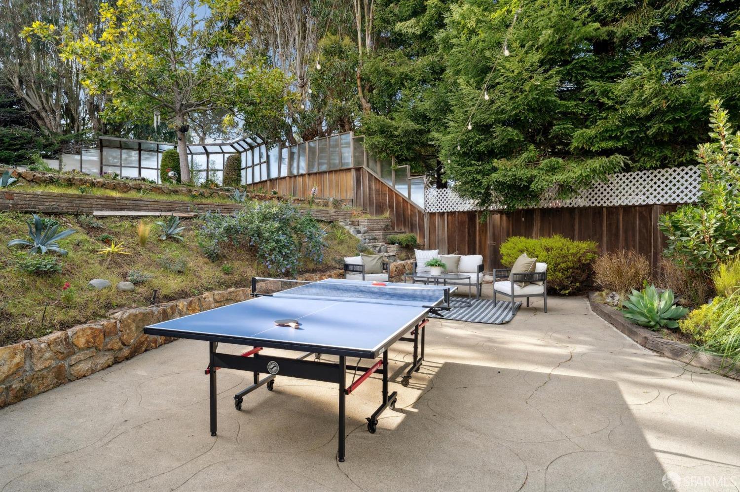100 Stonecrest Drive San Francisco, CA 94132 - Photo 45 of 64 a view of a patio with table and chairs under an umbrella with large trees