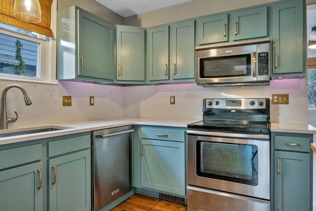 a kitchen with stainless steel appliances granite countertop a sink stove and microwave
