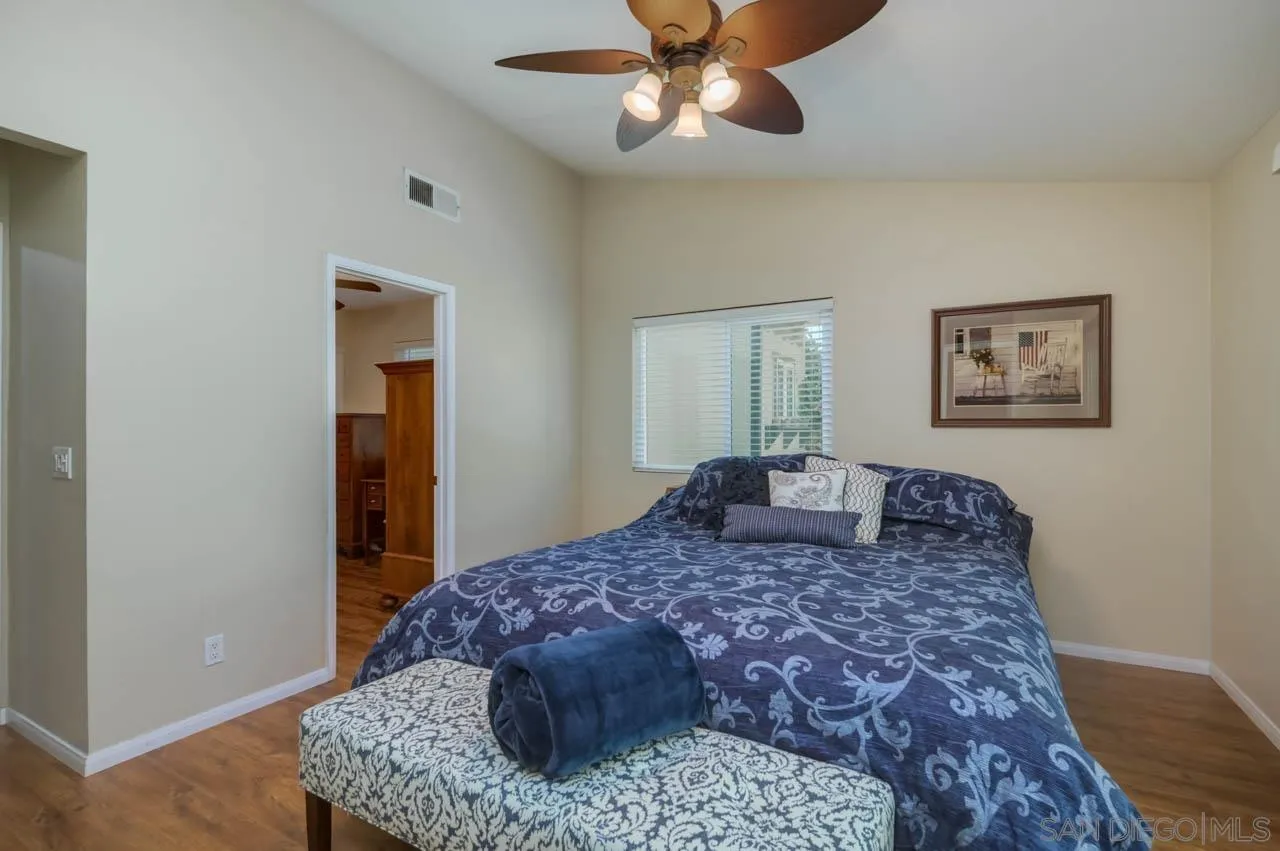 13499 Khuram Street Lakeside, CA 92040 - Photo 27 of 50 a large bedroom with a large bed and a chandelier