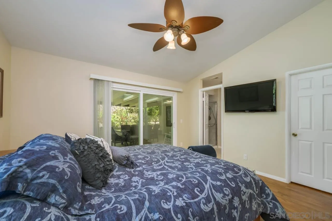 13499 Khuram Street Lakeside, CA 92040 - Photo 28 of 50 a bedroom with a large bed and a flat tv screen
