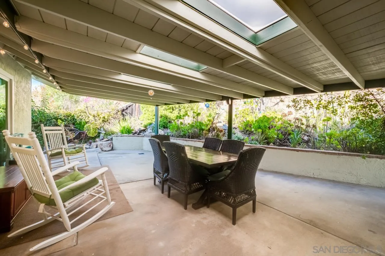 13499 Khuram Street Lakeside, CA 92040 - Photo 30 of 50 a view of a patio with table and chairs and floor to ceiling window with wooden floor