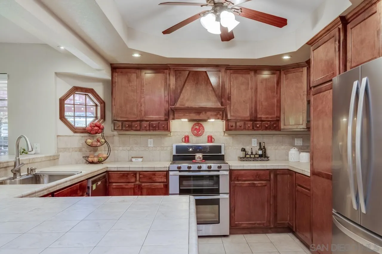 13499 Khuram Street Lakeside, CA 92040 - Photo 8 of 50 a kitchen with kitchen island granite countertop a sink stainless steel appliances and cabinets