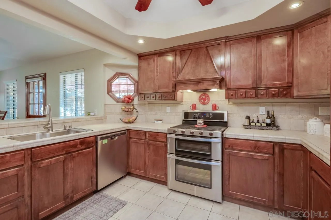 13499 Khuram Street Lakeside, CA 92040 - Photo 9 of 50 a kitchen with a stove sink and cabinets