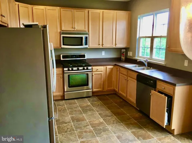 a kitchen with a stove a sink and a microwave