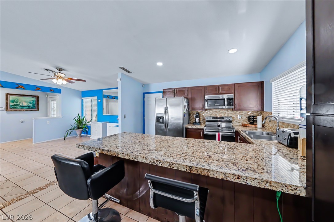 3107 Trueno Road Henderson, NV 89014 - Photo 17 of 37 A well-appointed kitchen features a large granite island and stainless steel appliances.
