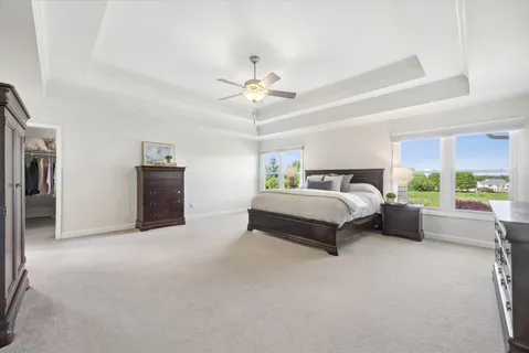a spacious bedroom with a bed and a chandelier
