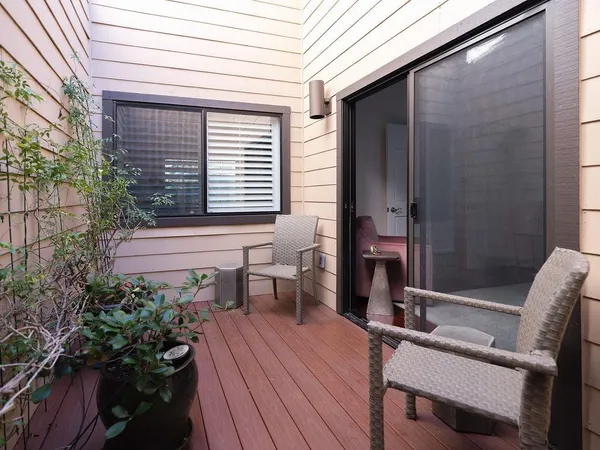 a view of a balcony with chairs and wooden floor