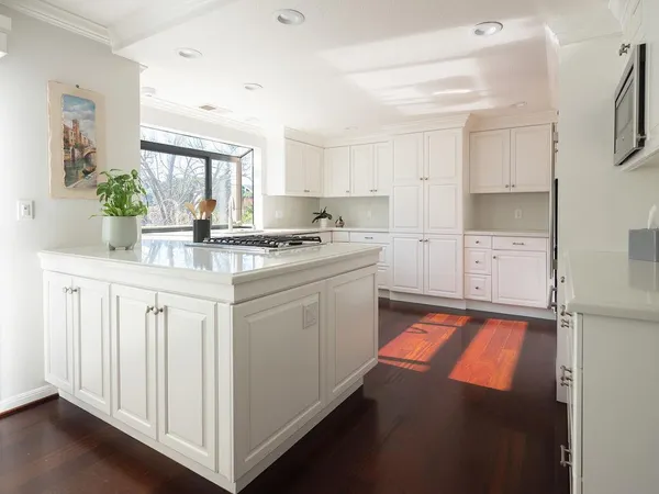 a kitchen with white cabinets and white appliances