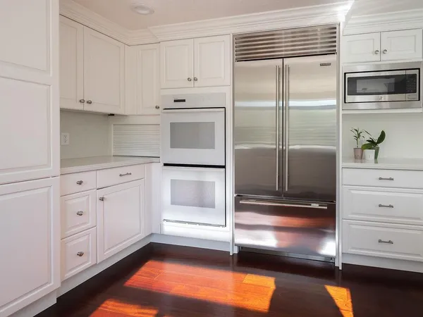 a kitchen with white cabinets and a refrigerator
