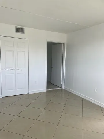 an empty room with a bench and cabinet