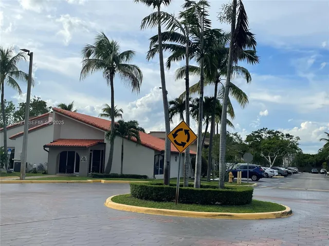 a view of a park with plants and palm trees