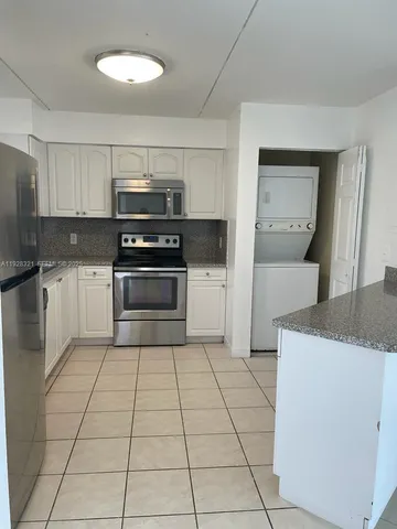 a kitchen with granite countertop a stove top oven and cabinets