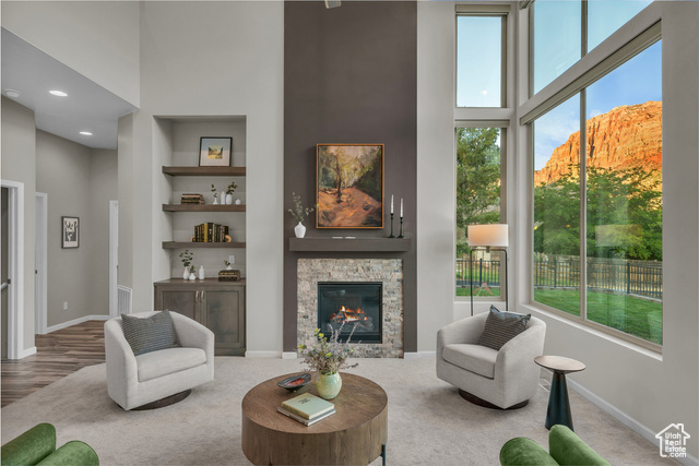 101 Chuckwalla Lane Springdale, UT 84767 - Photo 3 of 51 Living room featuring a high ceiling, a fireplace, built in shelves, and carpet flooring