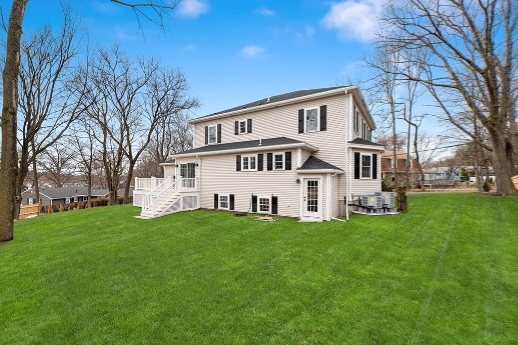 21 McCullough Road Saugus, MA 01906 - Photo 38 of 41 a house that is sitting in the grass with large trees and plants