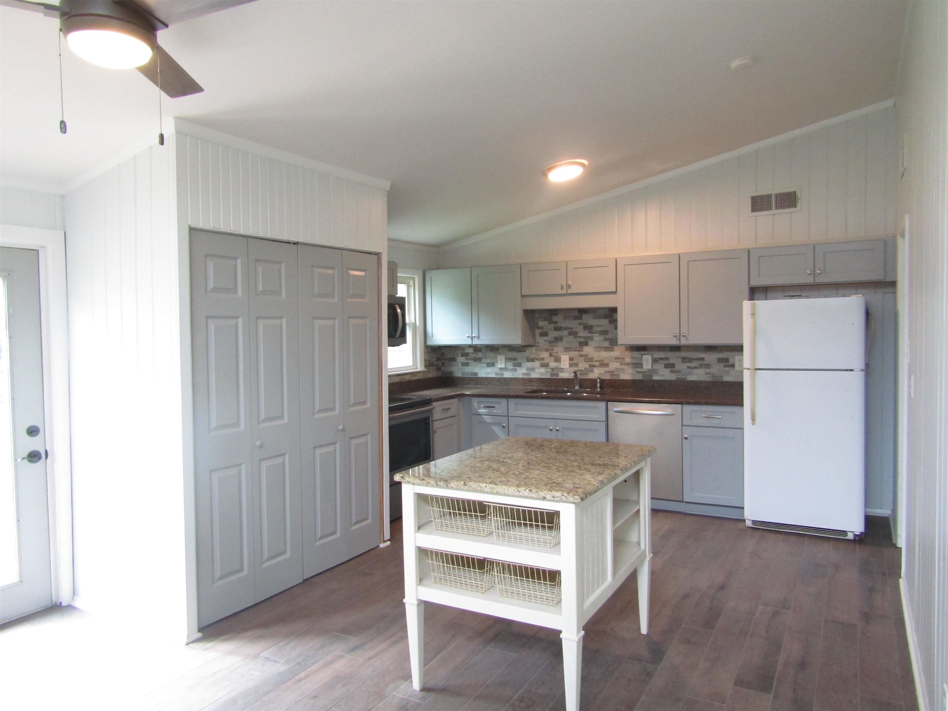 261 North Yates Road Memphis, TN 38120 - Photo 8 of 19 a kitchen with a refrigerator and white cabinets