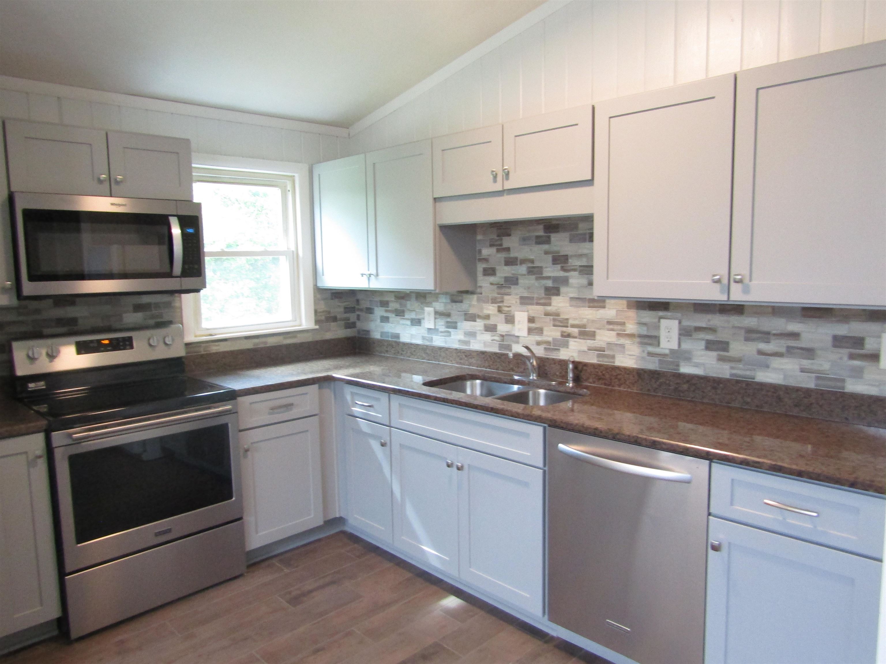 261 North Yates Road Memphis, TN 38120 - Photo 9 of 19 a kitchen with granite countertop a sink cabinets and stainless steel appliances