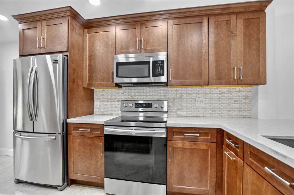 a kitchen with granite countertop a refrigerator stove and microwave