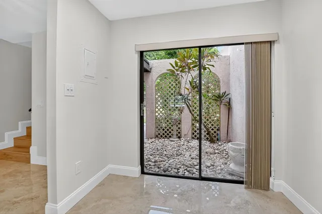 a view of an empty room with a chandelier fan