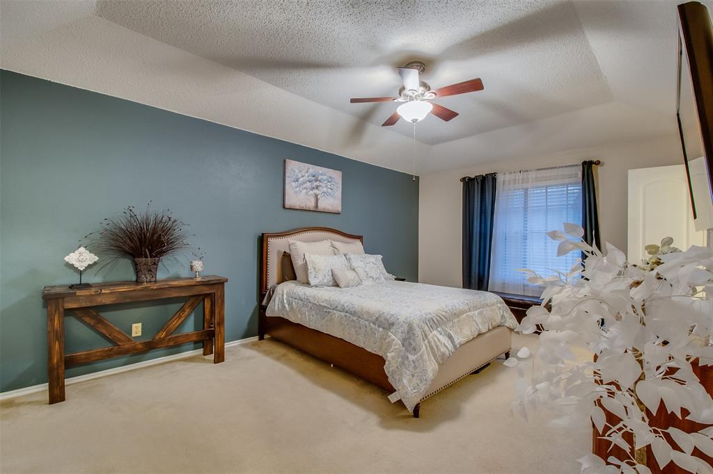 5718 Sagebrush Trail Arlington, TX 76017 - Photo 15 of 26 a spacious bedroom with a bed and a chandelier