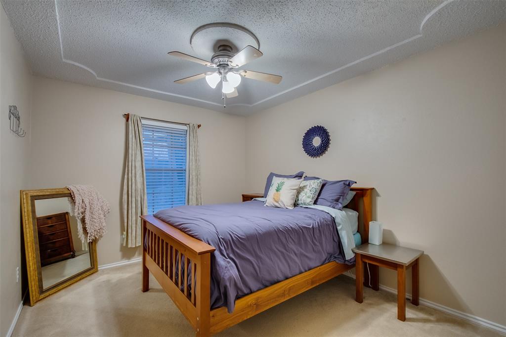 5718 Sagebrush Trail Arlington, TX 76017 - Photo 21 of 26 a bedroom with a bed and a chandelier