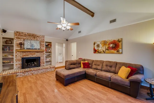 a living room with furniture a fireplace and a ceiling fan
