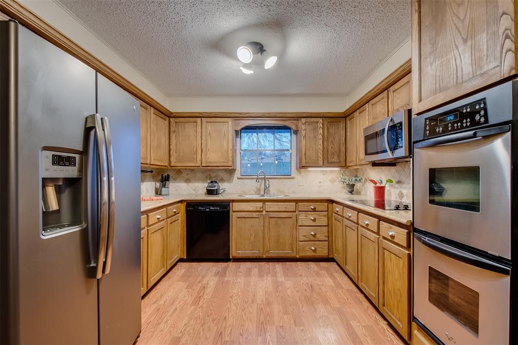 5718 Sagebrush Trail Arlington, TX 76017 - Photo 9 of 26 a kitchen with stainless steel appliances granite countertop a refrigerator a stove top oven a sink and dishwasher