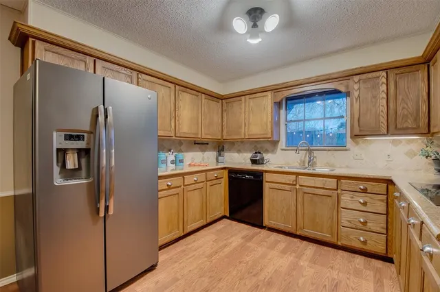 a kitchen with stainless steel appliances granite countertop a refrigerator sink and cabinets