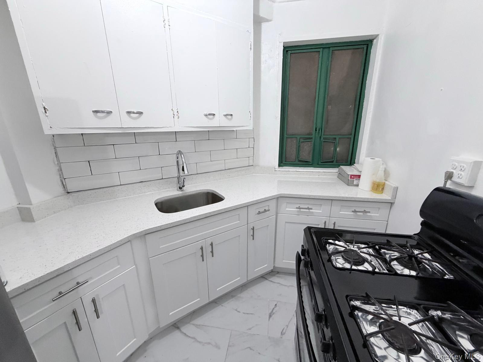 1558 Unionport Road, Unit 2D Bronx, NY 10462 - Photo 1 of 9 a kitchen with appliances a sink and cabinets