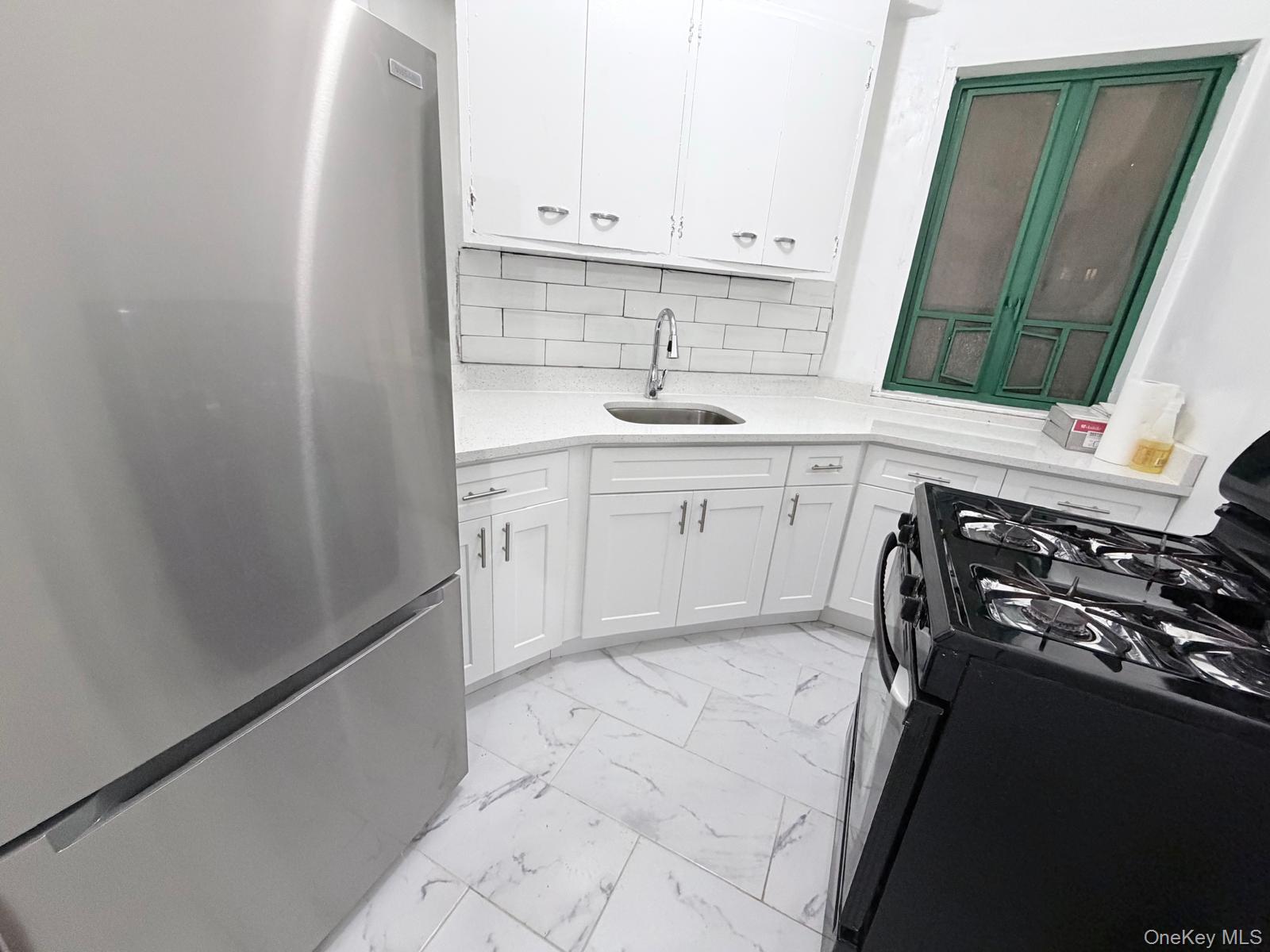 1558 Unionport Road, Unit 2D Bronx, NY 10462 - Photo 6 of 9 a kitchen with a sink stove and cabinets