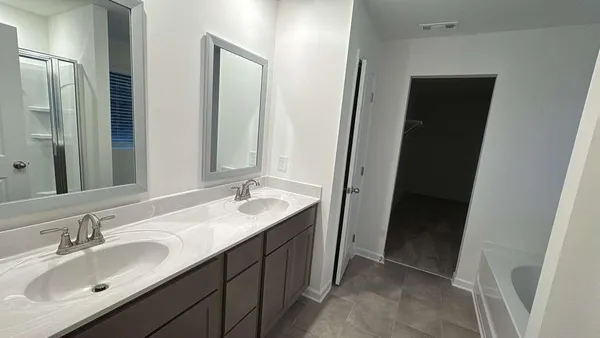 a bathroom with a double vanity sink and mirror