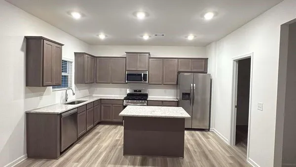 a kitchen with a sink a counter top space stainless steel appliances and cabinets