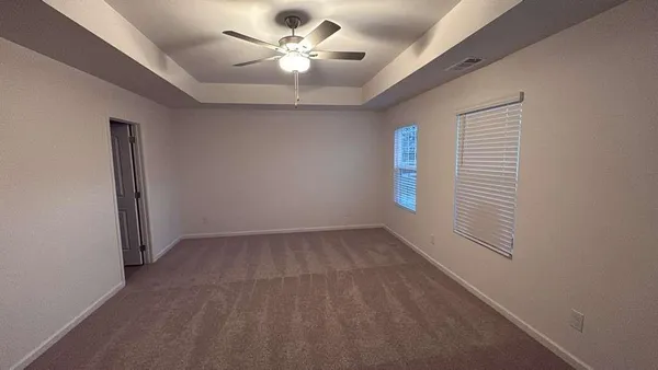 en empty room with windows and ceiling fan