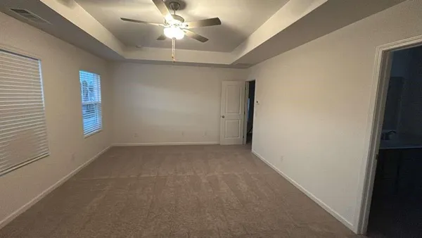 an empty room with windows and fan