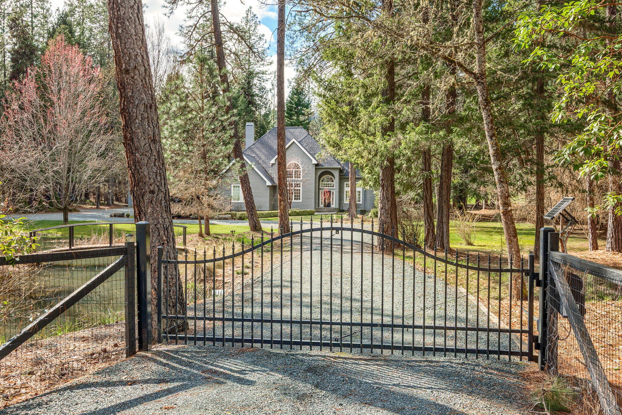 7081 Redthorne Road Rogue River, OR 97537 - Photo 2 of 58 a view of a brick house with large trees and a small yard