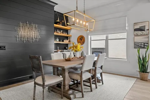 a view of a dining room with furniture a chandelier and wooden floor