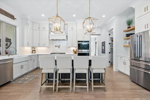 a kitchen with stainless steel appliances granite countertop a stove a sink and a refrigerator