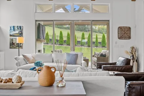 a kitchen with stainless steel appliances kitchen island granite countertop a table chairs in it and white cabinets