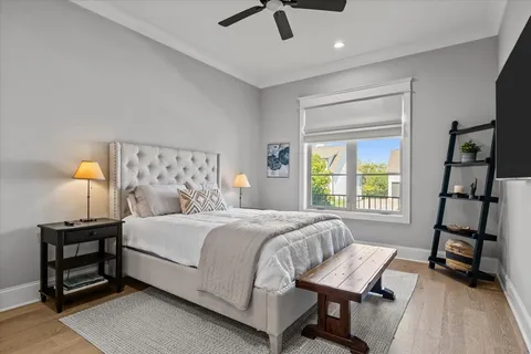 a bedroom with a bed a flat screen tv and a chandelier