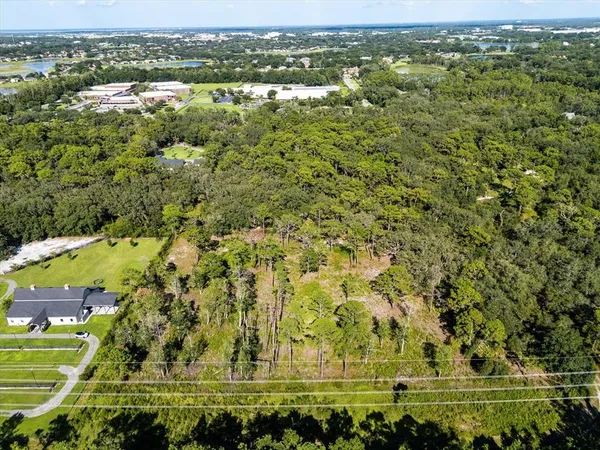 an aerial view of residential houses with outdoor space and trees