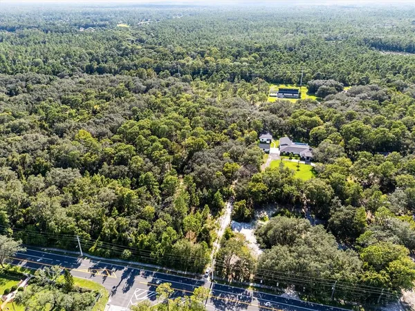 an aerial view of residential house with parking space and trees