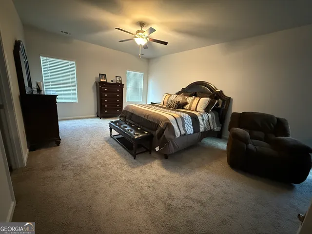 a spacious bedroom with a bed and a flat screen tv