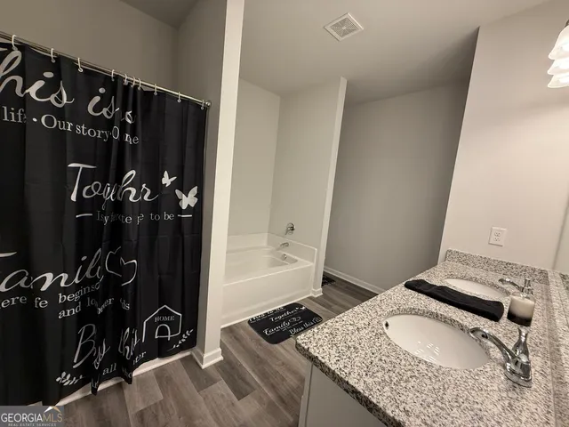 a bathroom with a granite countertop sink a toilet and shower