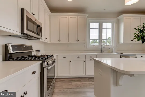 a kitchen with granite countertop a sink and a stove top oven