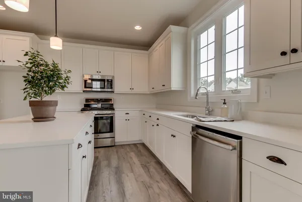 a view of a kitchen with a sink wooden floor and a window