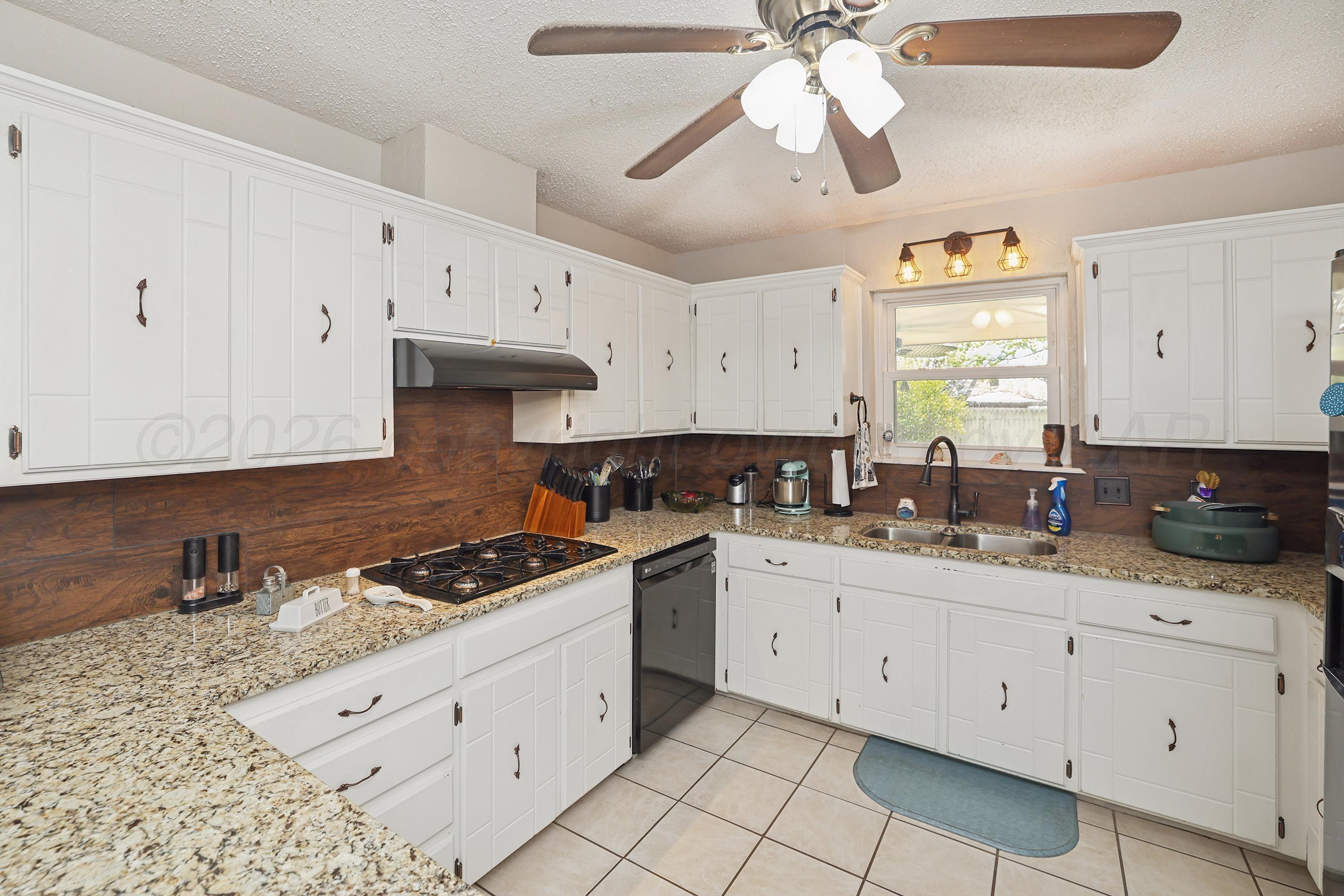 7903 Fenley Drive Amarillo, TX 79121 - Photo 18 of 20 a kitchen with granite countertop a sink a stove and cabinets