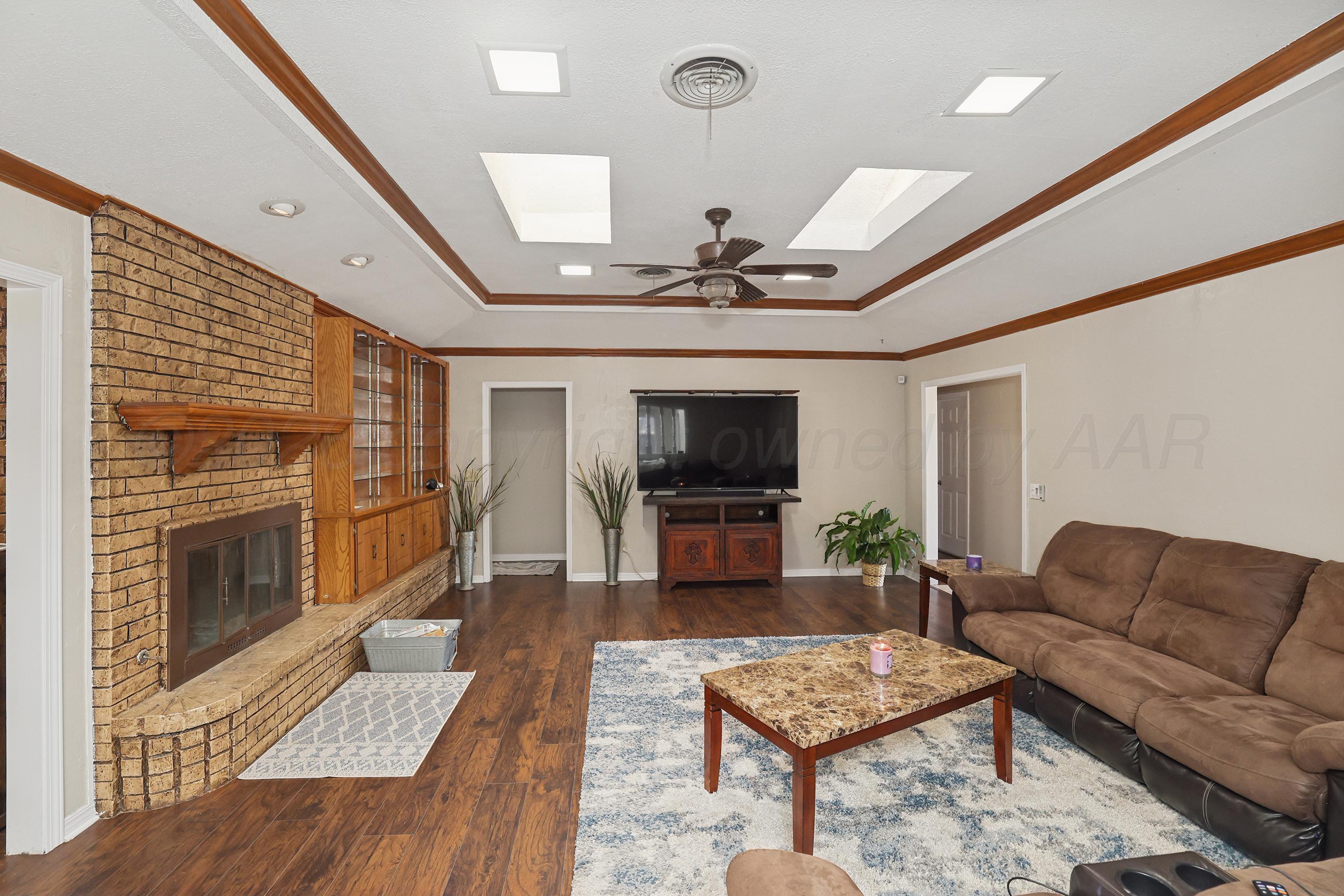 7903 Fenley Drive Amarillo, TX 79121 - Photo 5 of 20 a living room with furniture a flat screen tv and a fireplace
