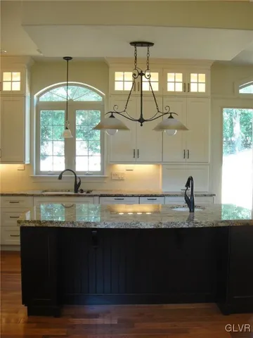 a kitchen with granite countertop a stove a sink and a window
