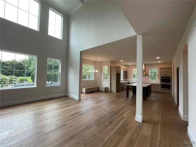an empty room with wooden floor and a large window