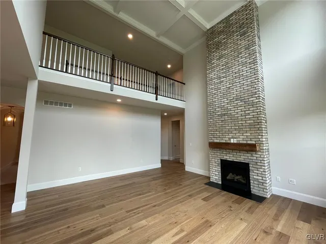 a view of a livingroom with wooden floor and a fireplace