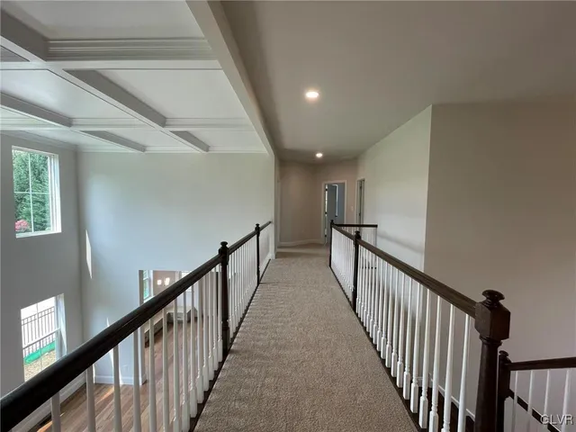 a view of a hallway with wooden floor and stairs